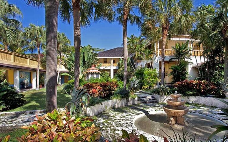 lush tropical garden with fountain palm trees walkway and buildings at bonnet house museum gardens ft lauderdale