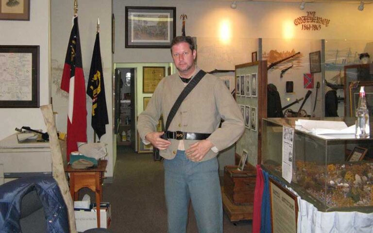 man in civil war uniform with displays at museum of southern history jacksonville