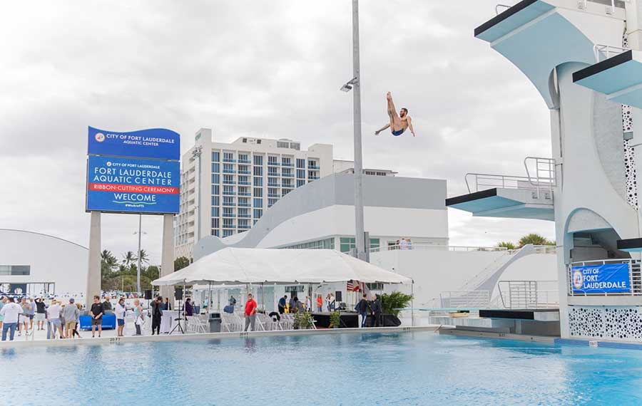 man mid high dive from tower with pool below at fort lauderdale aquatic center
