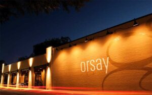night exterior of restaurant with sign mural at orsay jacksonville
