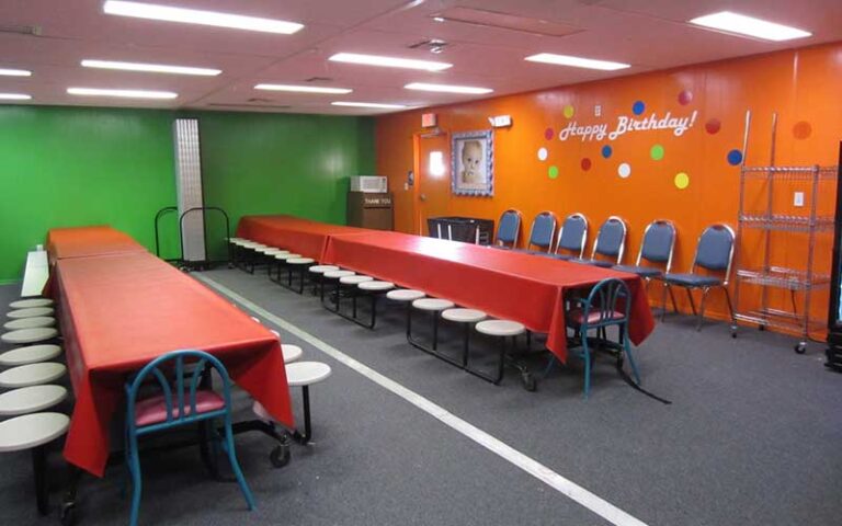 party room with bright colors and long tables at hands on childrens museum jacksonville
