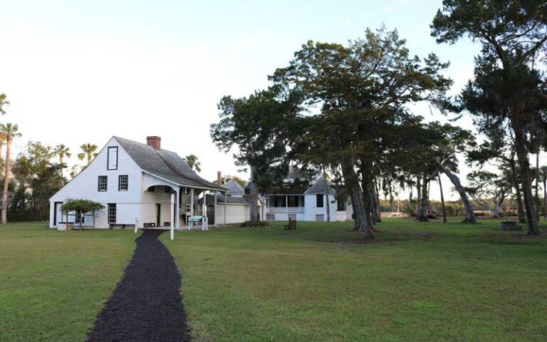 paved walkway leading to white historic buildings at kingsley plantation jacksonville