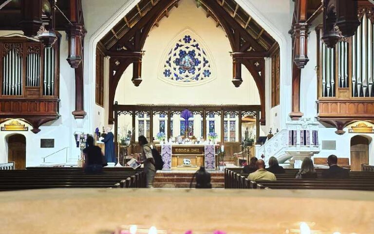 sanctuary of church with rose window and pipe organs and columns flanking pulpit at st johns cathedral jacksonville