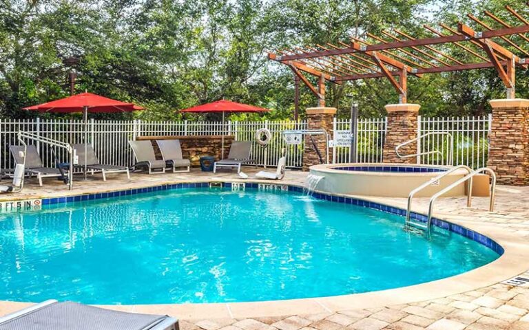 shady outdoor pool with jacuzzi at hotel indigo jacksonville deerwood park