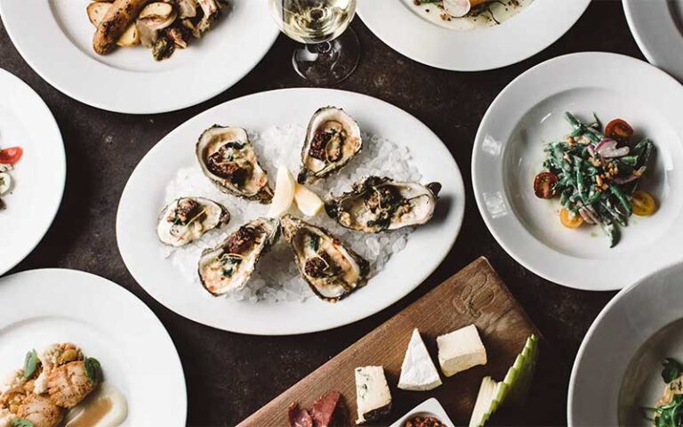 spread of entrees with oysters at orsay jacksonville