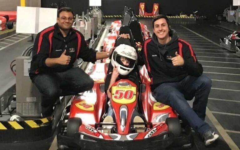 two workers helping a boy into a junior kart on the track at autobahn indoor speedway events jacksonville