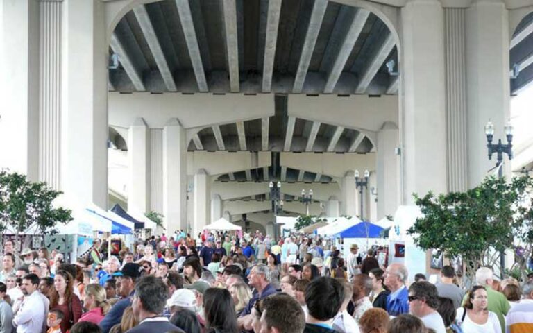 underpass with huge pylons and view over crowded marketplace at riverside arts market jacksonville