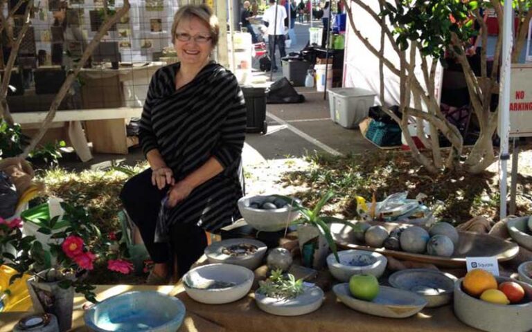 woman vendor with tables of art pottery at riverside arts market jacksonville