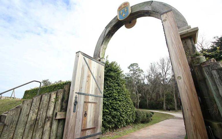wooden fortress arched gate with fence and trees at fort caroline national memorial jacksonville
