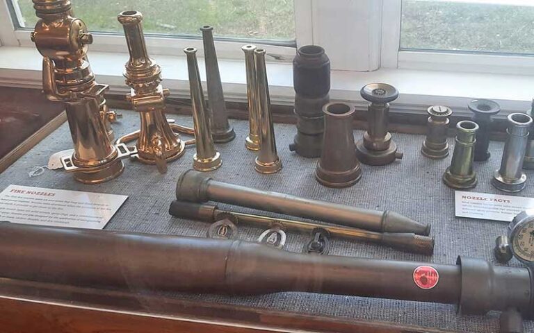 array of fire hose nozzles on exhibit table at orlando fire museum