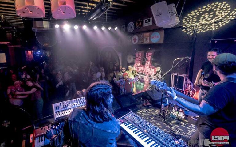 band with keyboards and guitars on stage with crowd in bar area at 1902 music hall jacksonville