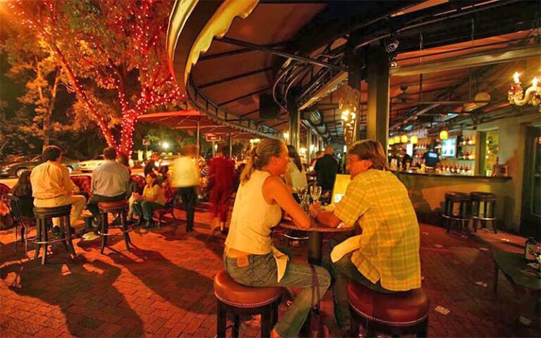 bar patio exterior with red lights high top tables and customers at greenstreet cafe miami