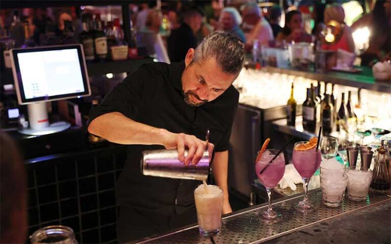 bartender pouring cocktail in busy bar area at time out market miami