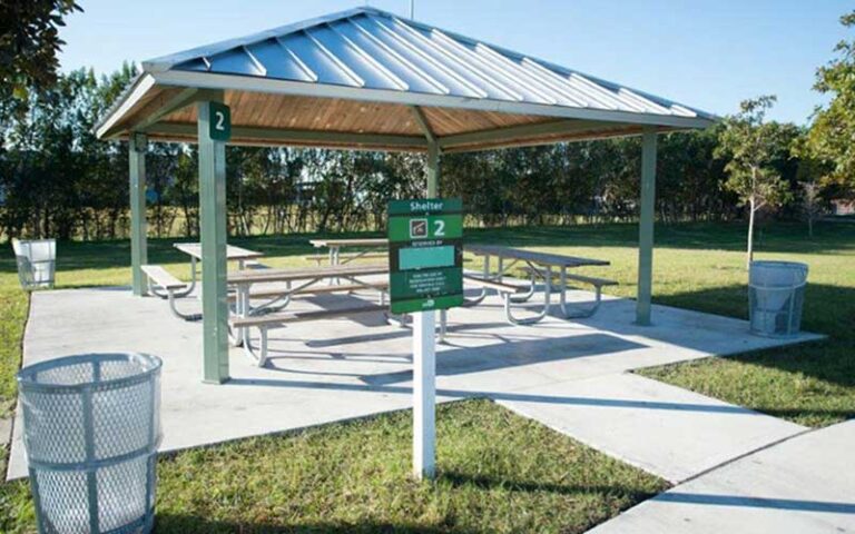 covered tables pavilion with trash receptacles and sign at matheson hammock park marina miami