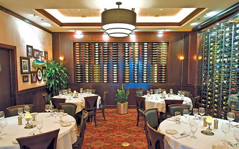 dining room with set tables and wine selection racks on back and side wall at trulucks miami