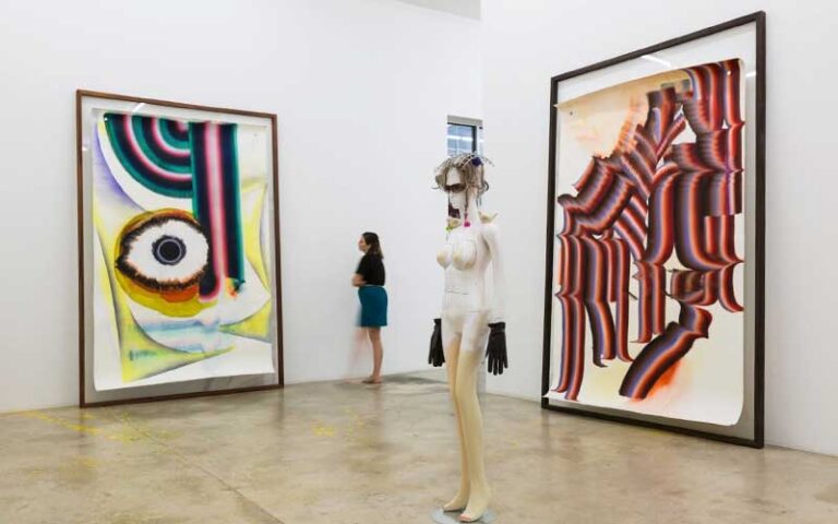 exhibit room with two large paintings and statue at rubell museum miami