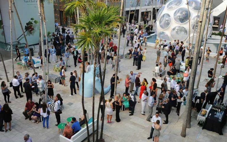 formal event in courtyard with globe art piece at miami design district