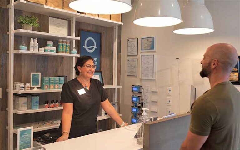 front desk with lamps and product shelves and lady greeting customer at be still float studio jacksonville