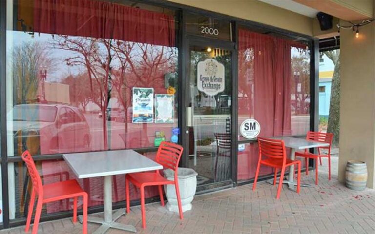 front exterior of store with red curtains in windows and sidewalk seating at grape grain exchange jacksonville