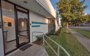 front exterior with sign and entrance along street with trees at be still float studio jacksonville