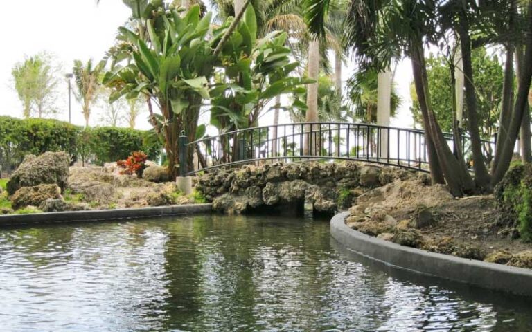 garden area with bridge over water and trees at bayfront park miami