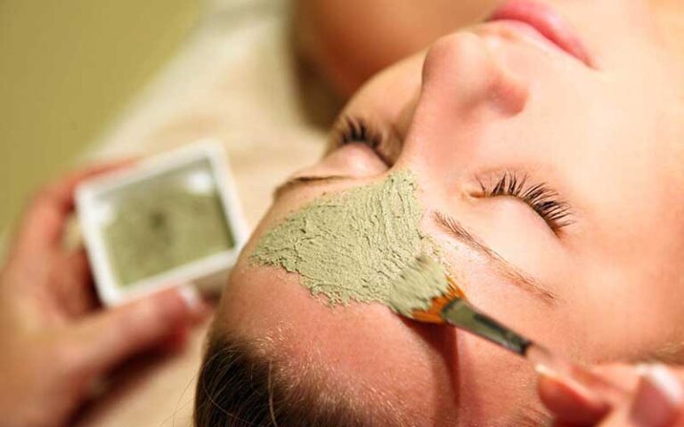 hands applying mask to womans face for facial at spa at one ocean resort jacksonville