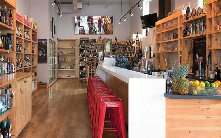 interior of bar with wood shelves and red seats at grape grain exchange jacksonville