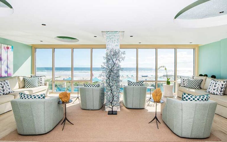 lobby seating area with aqua tones and beach view at spa at one ocean resort jacksonville