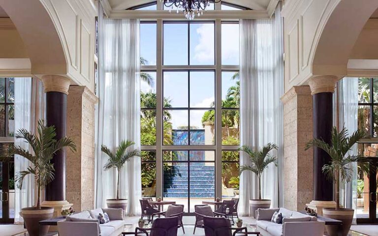 lobby with atrium chandelier seating and fountain outside at ritz carlton miami