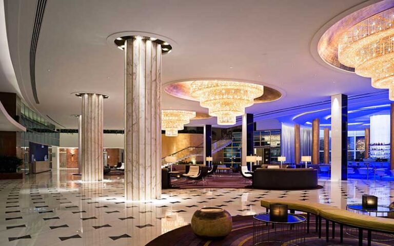 lobby with ball room style chandeliers and stairs at fontainebleau miami beach