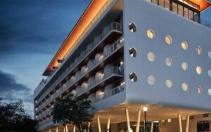 night exterior of building with port hole windows and modern design at mr c miami