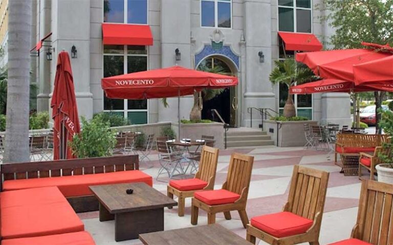 patio area exterior of restaurant with red umbrellas and seating at novecento miami