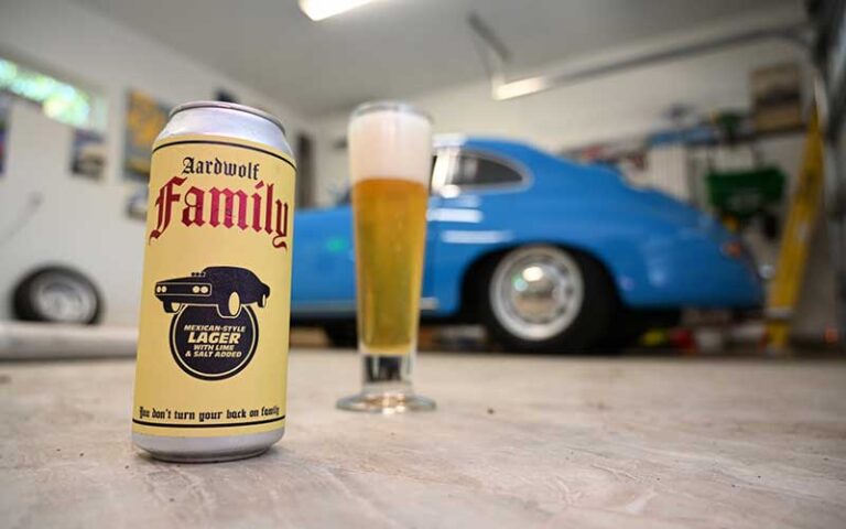 pint can of beer with logo and classic car in garage at aardwolf brewing company jacksonville