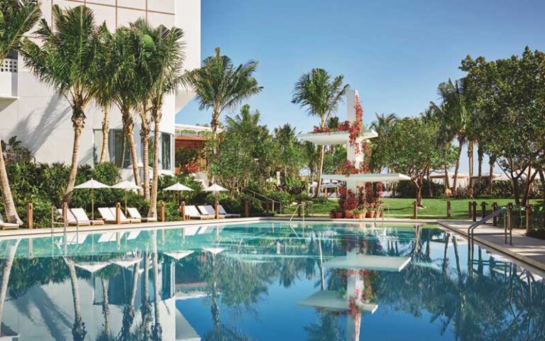 pool area with trees and diving tower with flowers at the miami beach edition