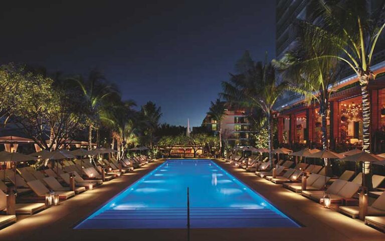 pool area with trees at night with lighting at the miami beach edition