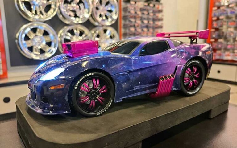 purple and pink supercar model toy with metal rims on wall behind at ridemakerz store orlando