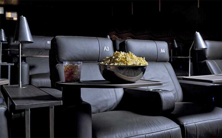row of reclining theater seats with popcorn and soda on tray at cinepolis luxury cinemas at cocowalk miami