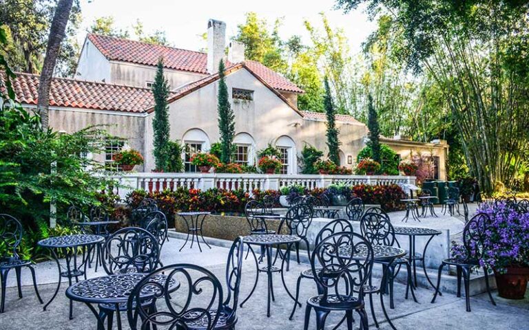 spanish style building with patio black seating and trees at marie selby botanical gardens sarasota