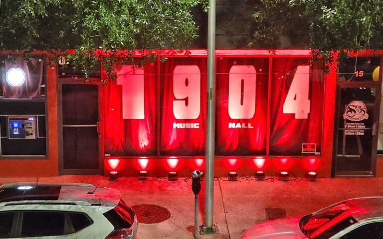 store front windows with red lights and sign on curtains along street with cars at 1902 music hall jacksonville