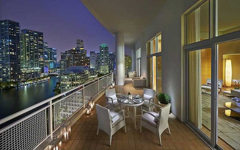 suite with balcony tables chairs view of bay and city at mandarin oriental miami