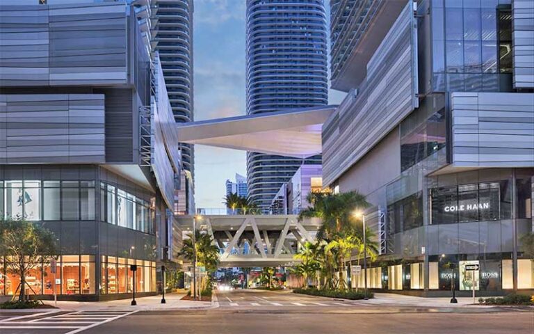 twilight view at street level of stores with skywalk at brickell city centre miami