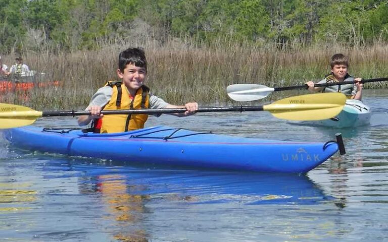 two boys kayaking in separate crafts at kayak amelia jacksonville