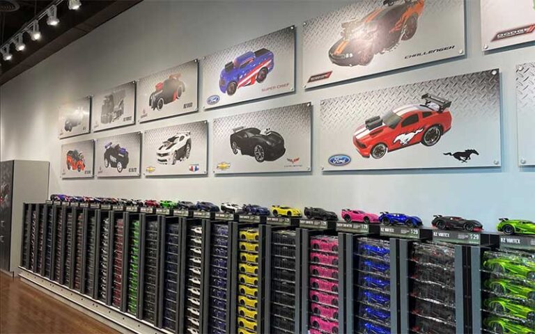 wall rack full of toy cars with posters of custom cars at ridemakerz store orlando