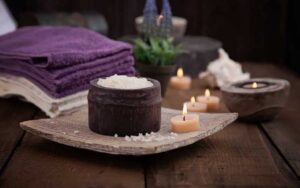 wooden tabletop with purple towels salt candles and lavender at wild berry tea spa jacksonville