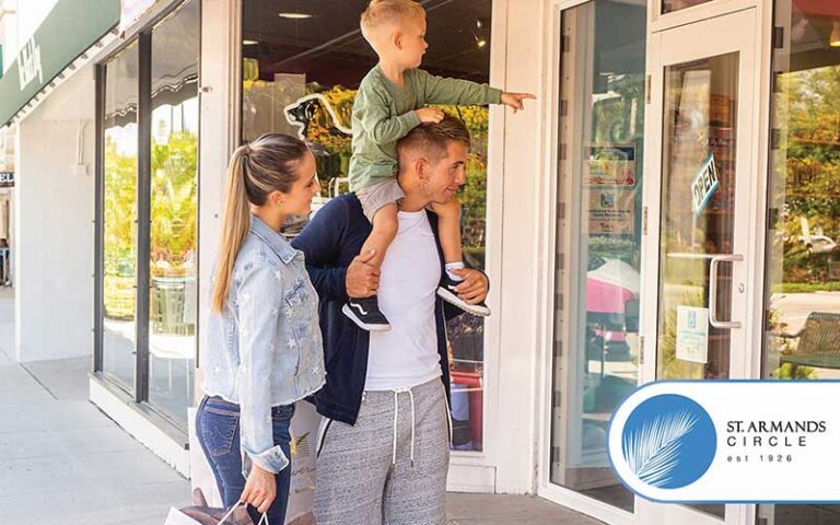 young couple with toddler on dads shoulders window shopping on avenue with stores at st armands circle sarasota