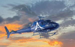 blue helicopter flying in orange sunset sky at apex air helcopter tours kissimmee