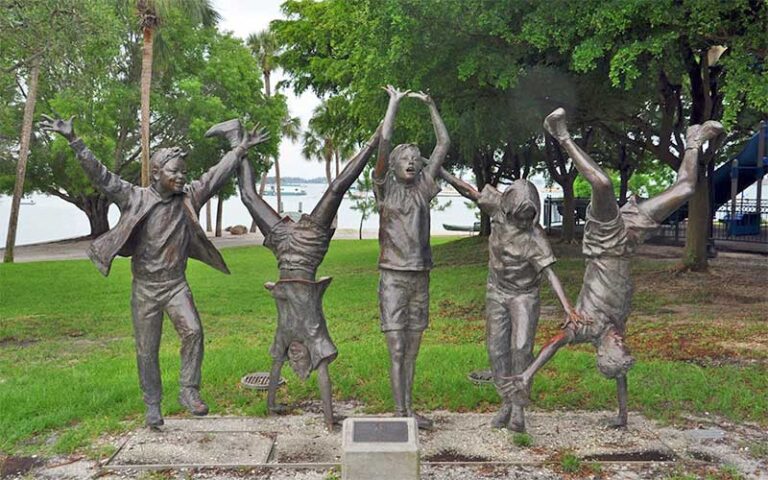 bronze statue of kids playing in park at bayfront park sarasota