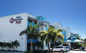 corner exterior of hotel with sign and parking at best western plus siesta key gateway sarasota