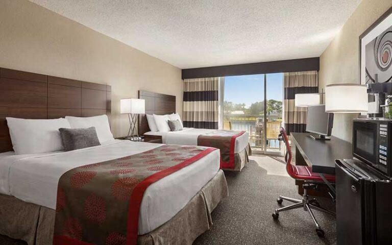 double bed room with balcony view at ramada by wyndham sarasota waterfront