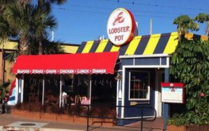 front exterior of restaurant with blue yellow and red awnings at lobster pot sarasota